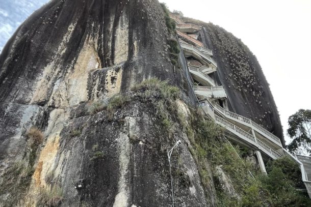 Ground view of El Penol Rock and entrance building with stair case leading to top in Guatape, Columbia