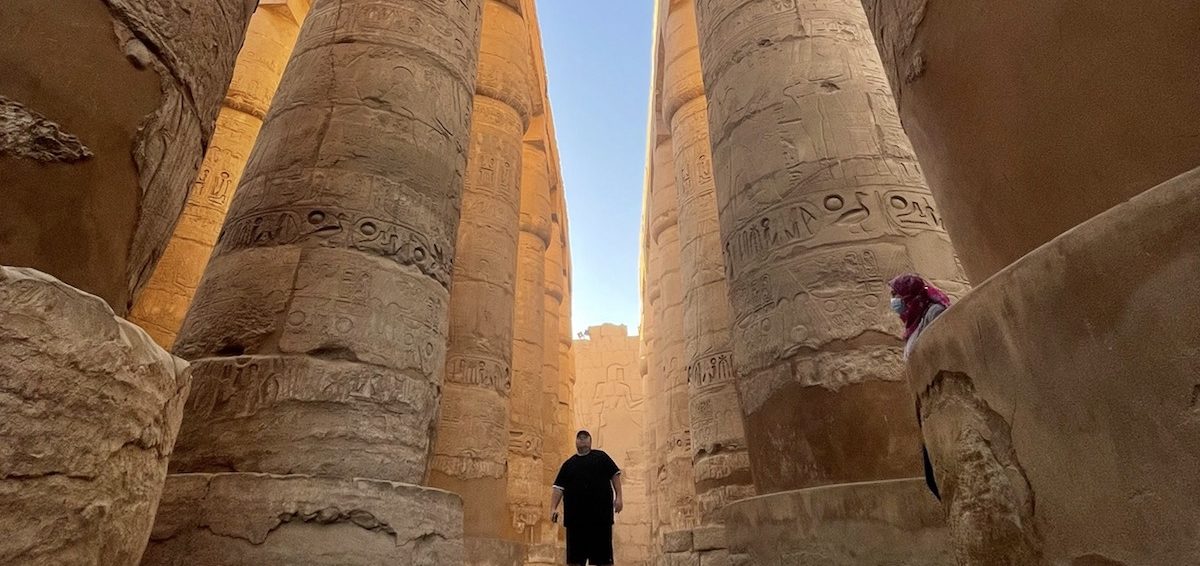 Standing in between the huge columns in the Temple of Karnak in Luxor