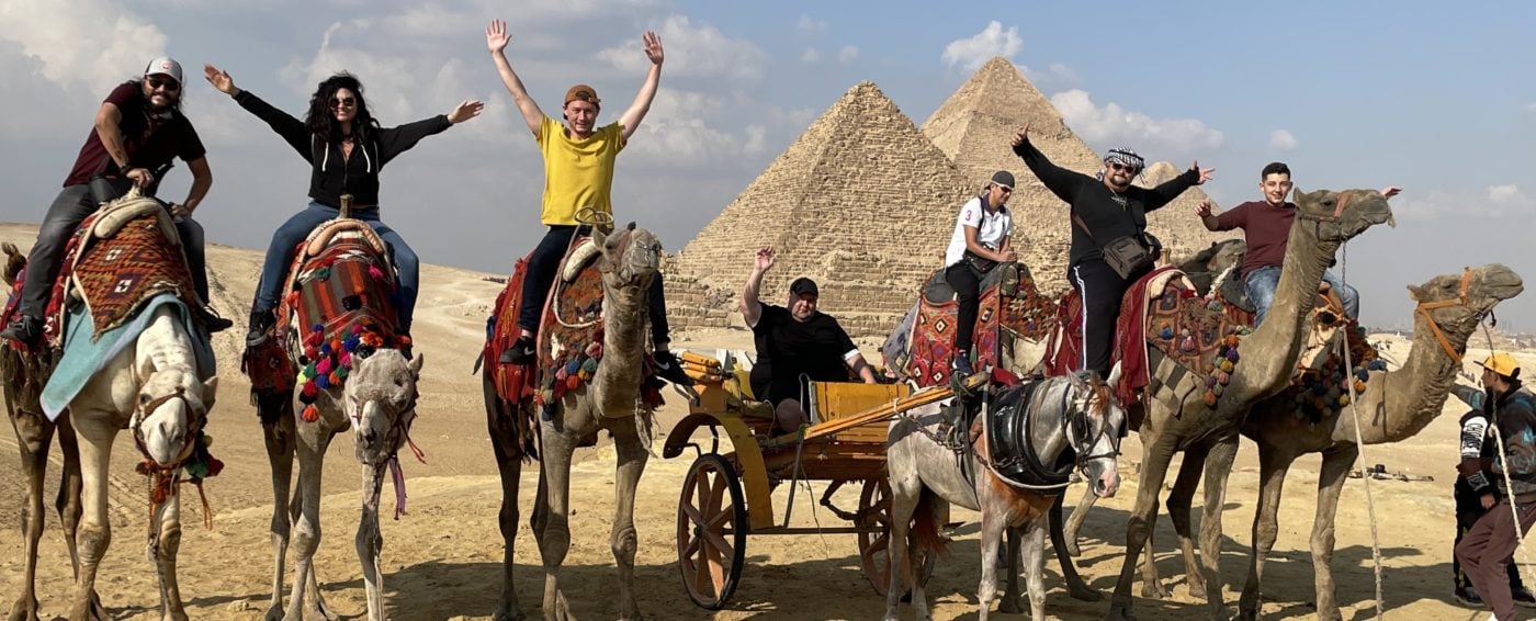 In front of the Great Pyramids of Giza on camels