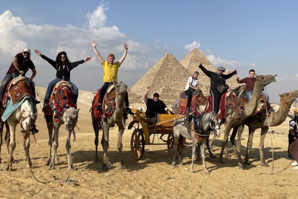 In front of the Great Pyramids of Giza on camels