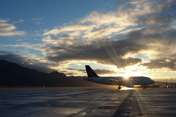 View of an airplane parked at the gate at sunrise