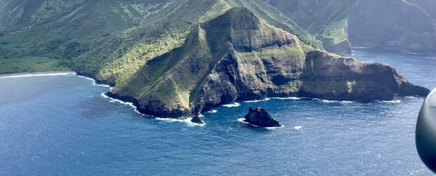 Aerial view of green island surrounded by blue ocean water