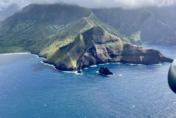 Aerial view of green island surrounded by blue ocean water