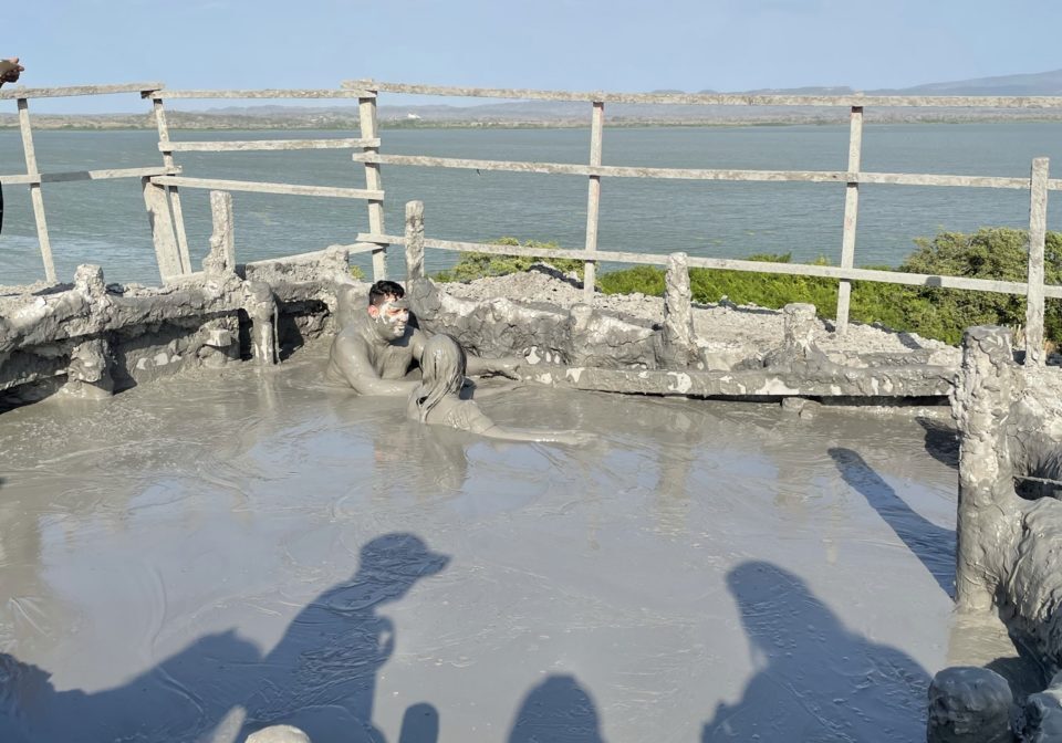 Person sitting inside healing mud bath of El Totumo mud volcano in Cartagena, Columbia