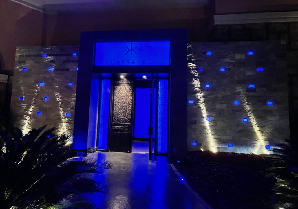Vibrant blue lights around the sign of the restaurant Hakkasan in Dubai