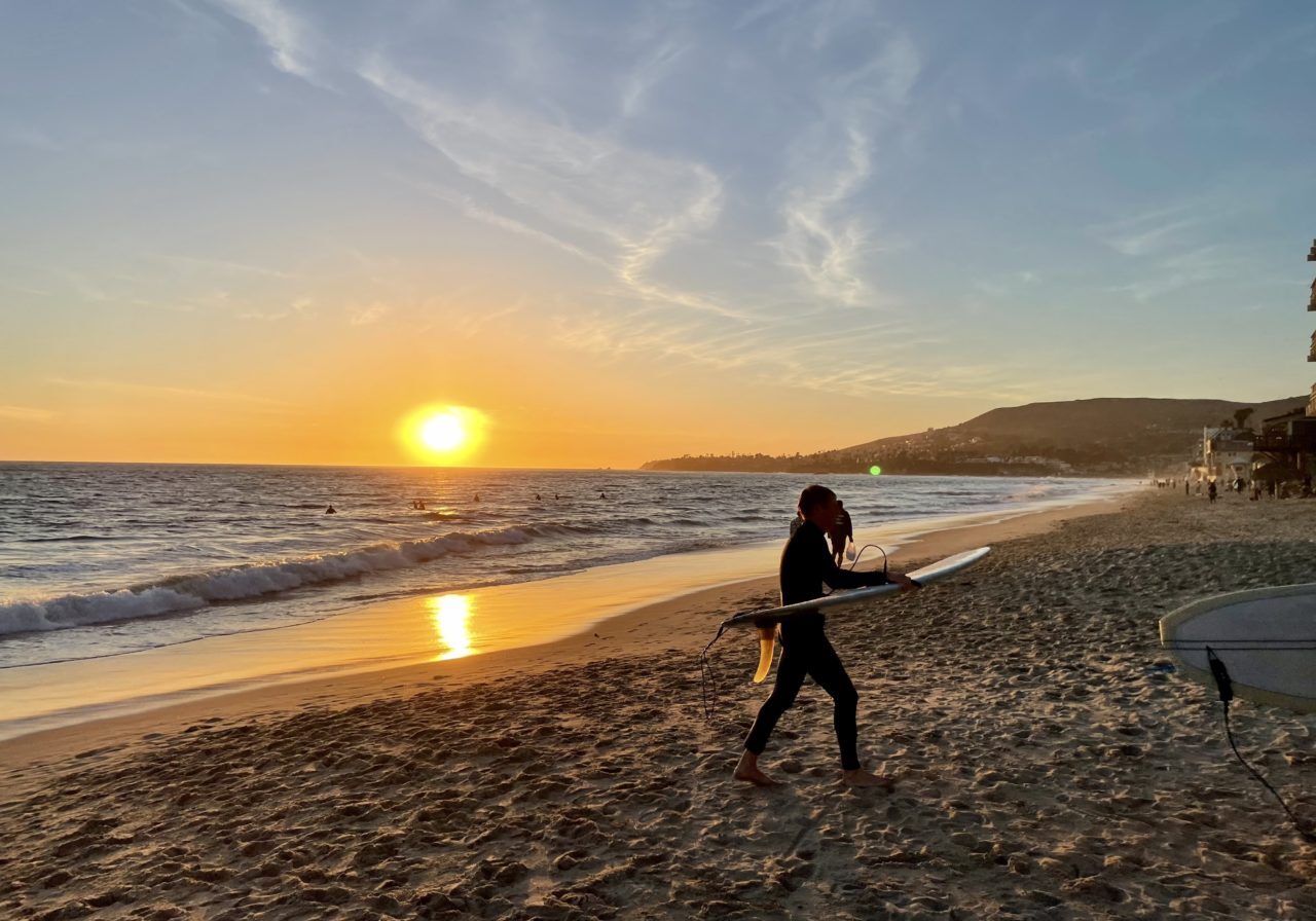 Laguna beach, California_featured a surfer leaving laguna beach, california at sunset